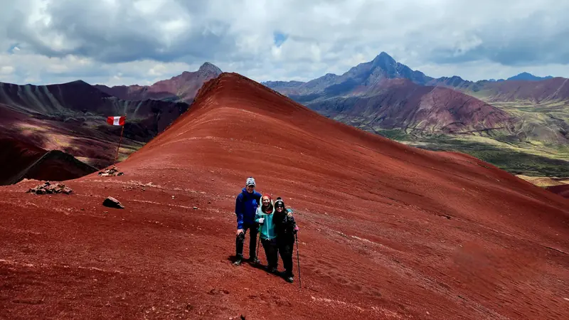Travelers standing on the deep red slopes of the Red Valley