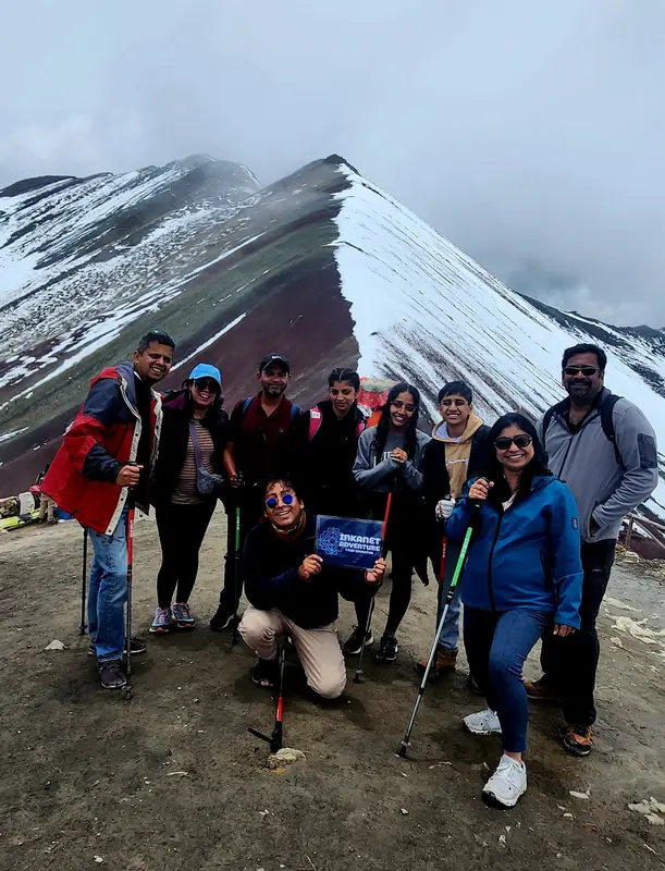 A group of travelers at the Vinicunca viewpoint after a fresh snowfall