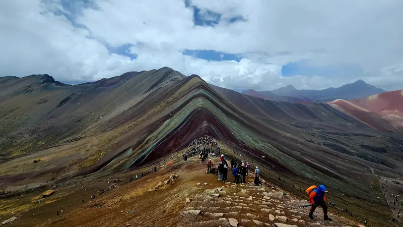 The striped mineral ridge of Rainbow Mountain seen from the viewpoint path